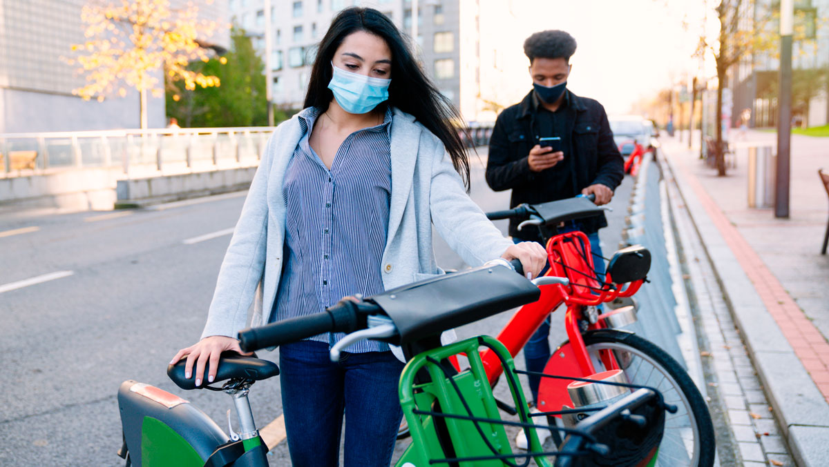 people in masks riding a bicycle